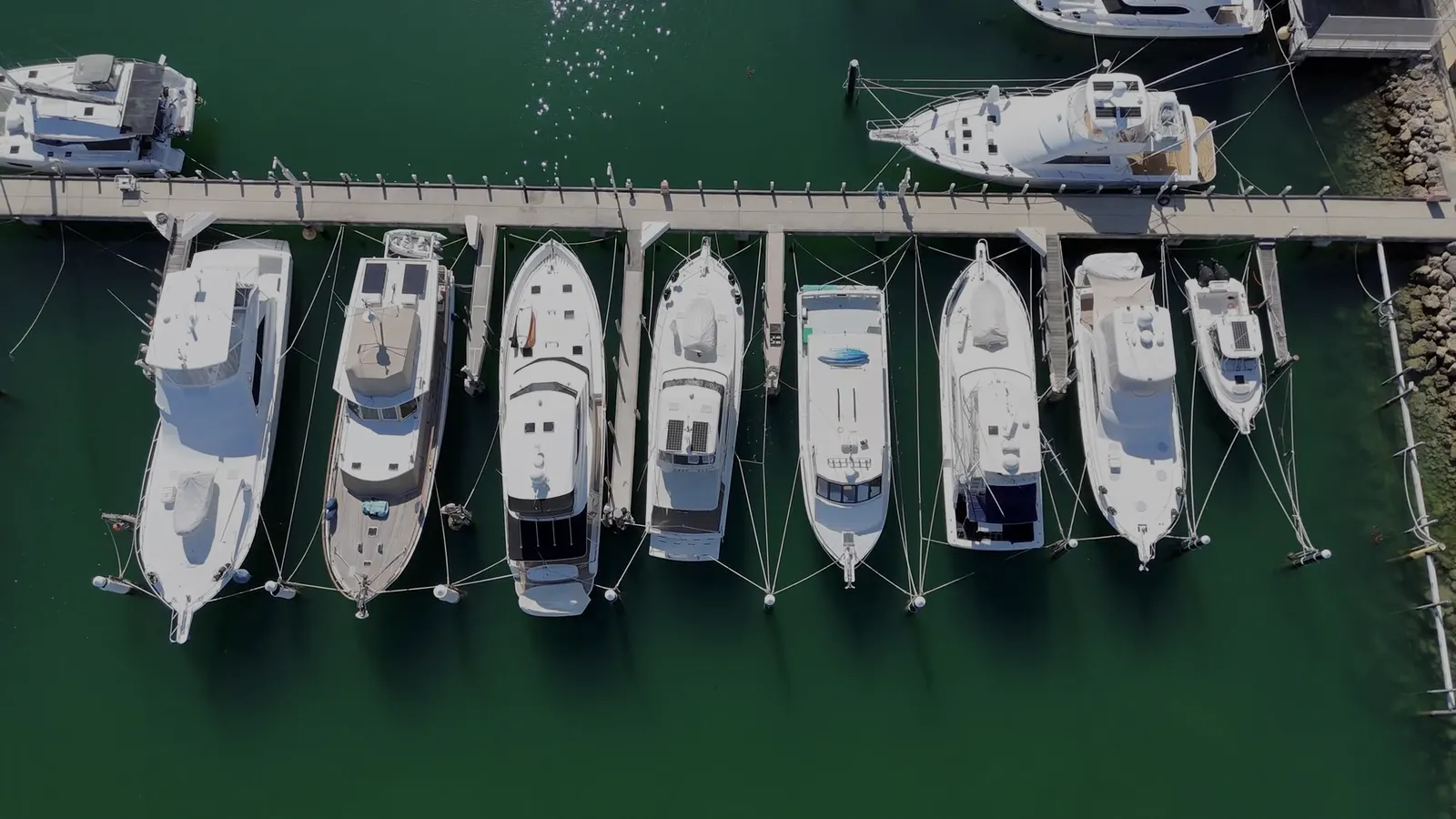 Marina mediterránea con barcos amarrados frente a edificios blancos